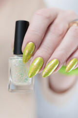 Female hand with long nails and a yellow green nail polish