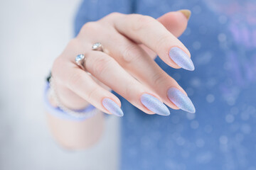 Woman hand with long nails manicure and light lilac and blue nail polish