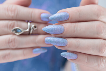Woman's beautiful hand with long nails and light blue and lilac manicure	