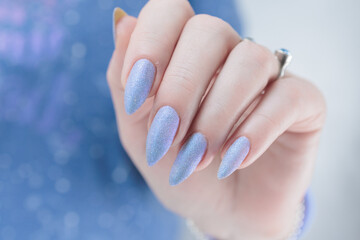 Woman's beautiful hand with long nails and light blue and lilac manicure	