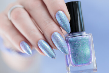 Woman's beautiful hand with long nails and light blue and lilac manicure	