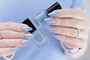 Woman hand with long nails manicure and light lilac and blue nail polish