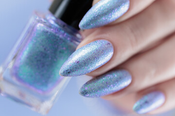 Woman hand with long nails manicure and light lilac and blue nail polish