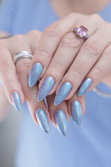 Woman hand with long nails manicure and light lilac and blue nail polish