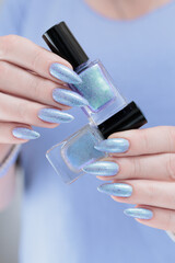 Woman hand with long nails manicure and light lilac and blue nail polish