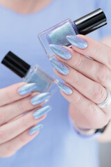 Woman hand with long nails manicure and light lilac and blue nail polish