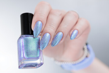 Woman hand with long nails manicure and light lilac and blue nail polish