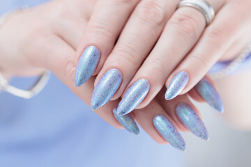 Woman hand with long nails manicure and light lilac and blue nail polish