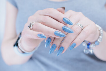 Womans hands with long nails light gray blue manicure	