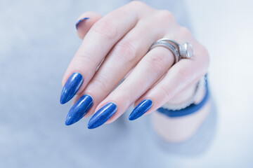 Woman's beautiful hand with long nails and blue manicure