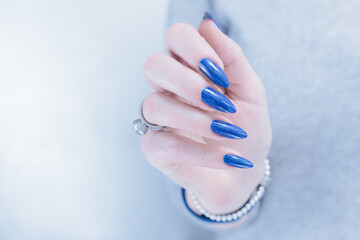 Woman's beautiful hand with long nails and blue manicure