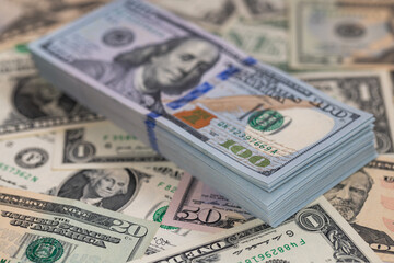 Pile of US 100 dollar banknotes on dollars background