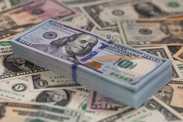 Pile of US 100 dollar banknotes on dollars background