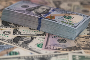 Pile of US 100 dollar banknotes on dollars background