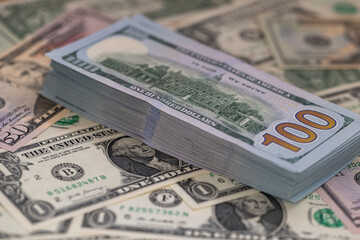 Pile of US 100 dollar banknotes on dollars background