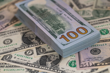 Pile of US 100 dollar banknotes on dollars background