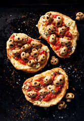 Halloween grilled sandwich, toasts with mushroom skulls and tomato sauce on black background, top view