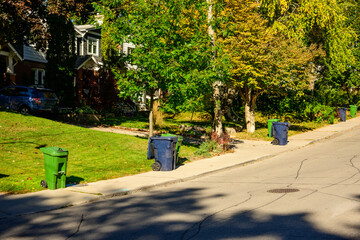 recycling and compost bins out for curbside pick up on a residential street in the city shot in...