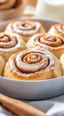 cinnabon Freshly baked cinnamon rolls with creamy icing displayed in a white dish on a cozy table setting with holiday decorations