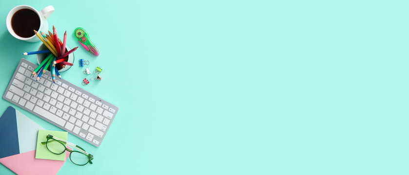 Workplace of graphic designer with PC keyboard, coffee and stationery on turquoise background with space for text, top view - Powered by Adobe