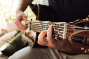 Hands of a person playing an acoustic guitar close up