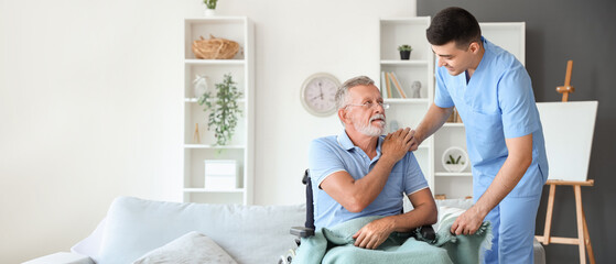 Male nurse with senior man in wheelchair at home
