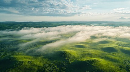 Obraz premium Aerial View of Rolling Green Hills with Fog and Clouds