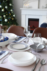 Festive table setting in living room with Christmas tree