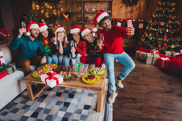 Full body photo of cheerful young people friends group take selfie photo celebrate cozy christmas party decor spacious apartment indoors