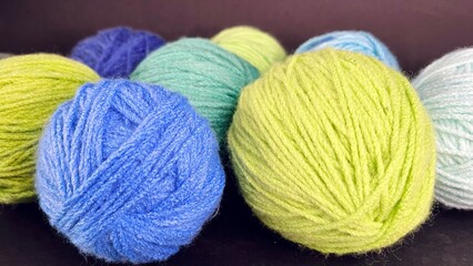 close up round skeins of yarn for knitting green blue brown colors