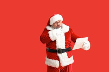 Thoughtful Santa Claus reading letter on red background