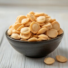 Fototapeta premium Crispy beige hazelnut wafers in a dark bowl.