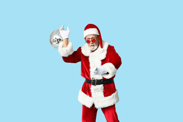Santa Claus in sunglasses with disco ball on blue background