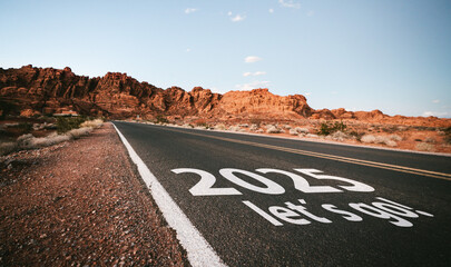 New year 2025 or start straight and beginning concept. Man ride on bike and the number 2025 start written on the road at sunset with lens flare. Concept of challenge or career path, business strategy.