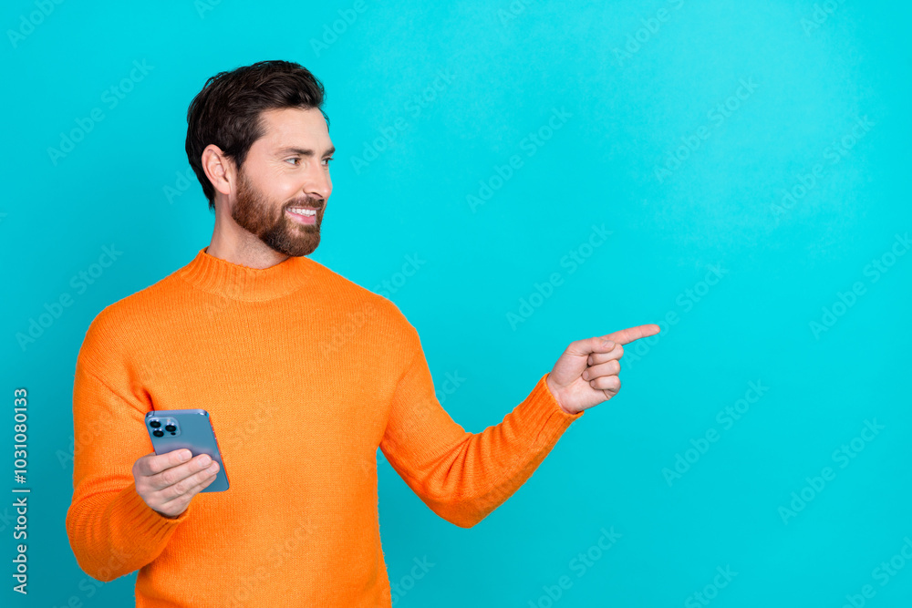 Aufkleber photo of attractive blogger man wear trendy clothes hold phone look empty space isolated on cyan col