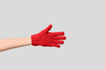 Hand in warm glove on grey background