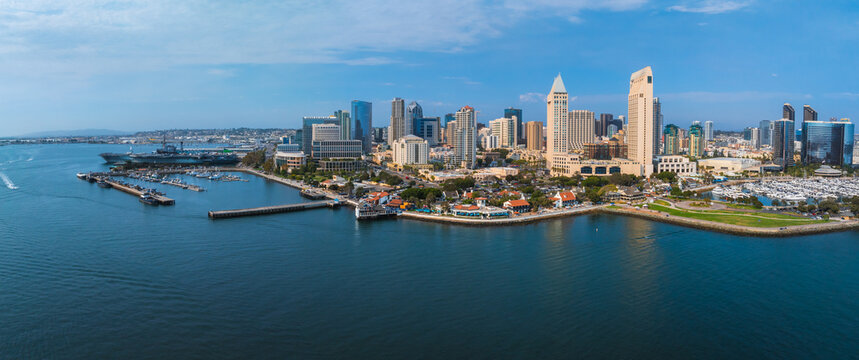 Downtown San Diego's skyline features modern skyscrapers and historic buildings, with One America Plaza and the USS Midway Museum by the marina.