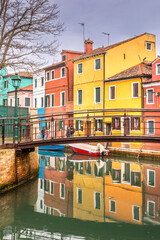 Burano, Italy - February 9, 2024: The famous colorful houses of the island of Burano along the canals, Italy