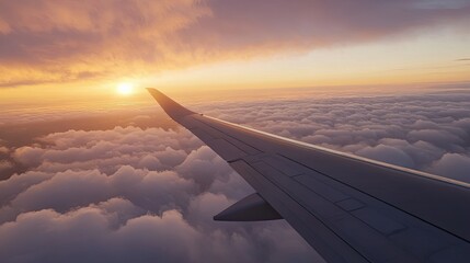 Airplane wing seen from a window during a beautiful sunset with fluffy clouds and a golden sky.