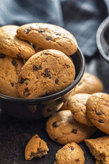 Biscotti frollini con gocce di cioccolato. Chocolate cookies in bowl on black table.