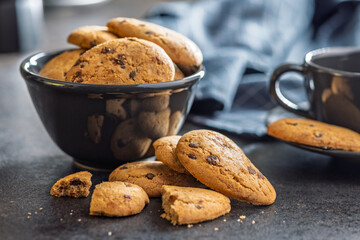 Biscotti frollini con gocce di cioccolato. Chocolate cookies on black table.