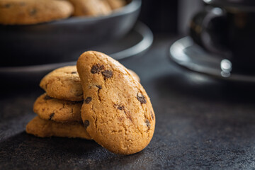 Biscotti frollini con gocce di cioccolato. Chocolate cookies on black table.