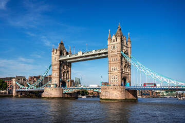 Fototapeta premium Tower Bridge over Thames river famous tourist landmark with cruise in river transportation for travel in center city of London, UK, United Kingdom, British or England in summer with clear blue sky