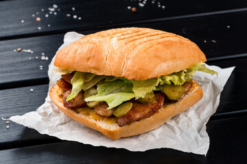 Fast food sandwich with chicken, lettuce, pickles and Dijon mustard.
