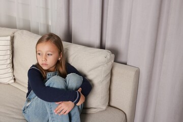Obraz premium Autism concept. Lonely little girl on sofa at home