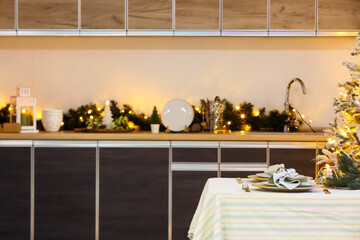 Beautiful table setting with utensils and Christmas decor on counters in kitchen
