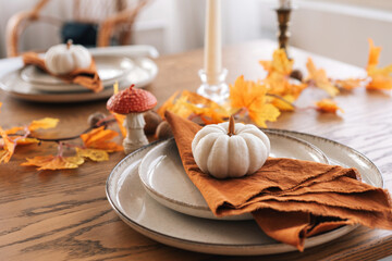 Autumn, fall, Halloween or Thanksgiving day table setting. Plates with yellow leaves and pumpkins