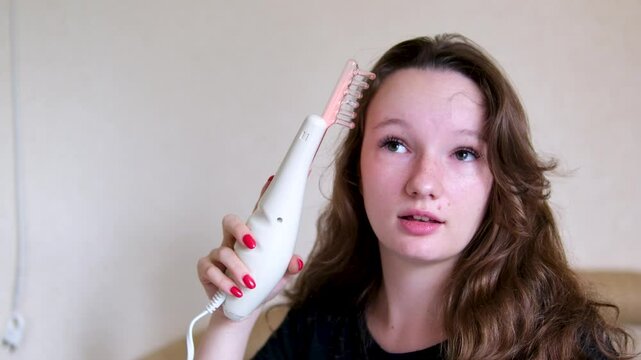  Application of darsonval for hair treatment procedure for young woman in beauty salon. 