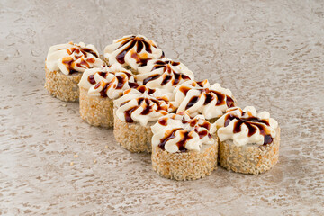 Set of sushi rolls with salmon fish, cream cheese, avocado, sesame and teriyaki sauce.