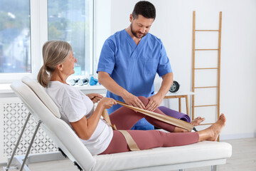 Physiotherapist working with senior patient in rehabilitation center